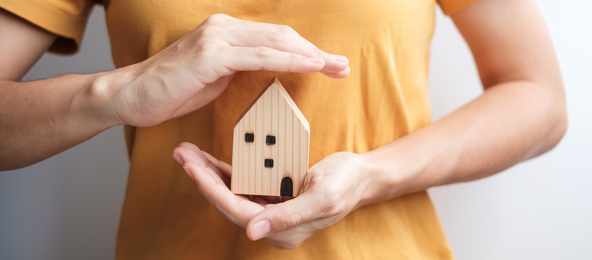 hand holding key with wooden Home model. Real estate, buy and sale, Property insurance, rental